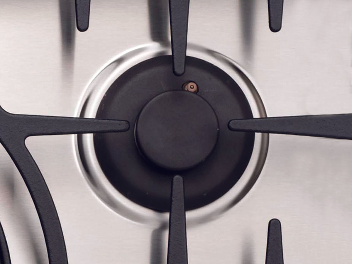Close-up of a Capital gas burner with iron grate and stainless steel.