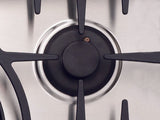Close-up of a Capital gas burner with iron grate and stainless steel.